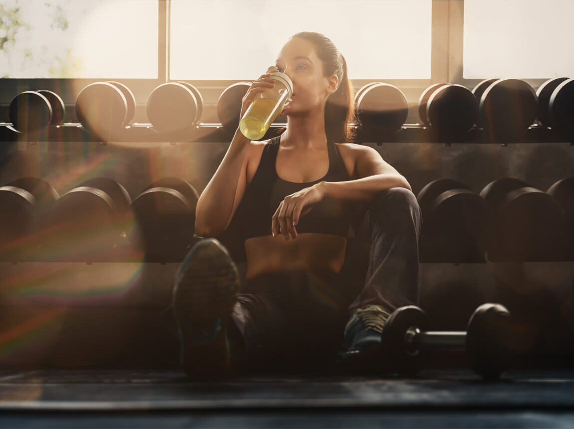 жінка з пляшкою води під час тренування 