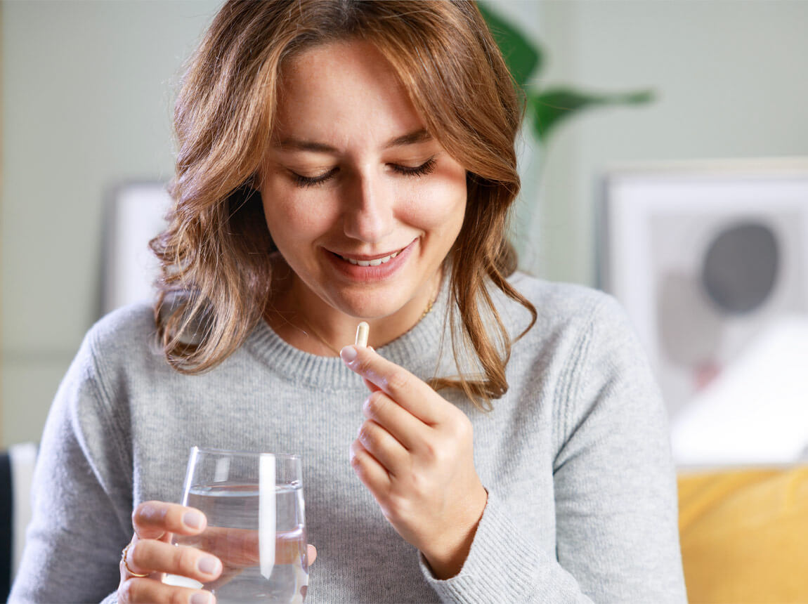 жінка з вітамінно-мінеральною капсулою 