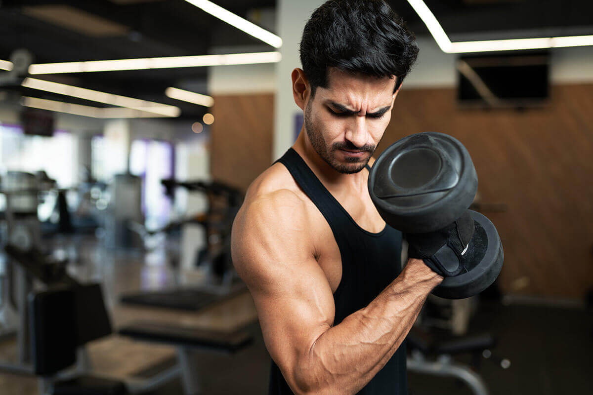 чоловік у спортзалі - тренування біцепсів 