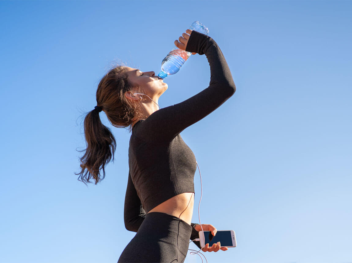 жінка з пляшкою води в спекотний день