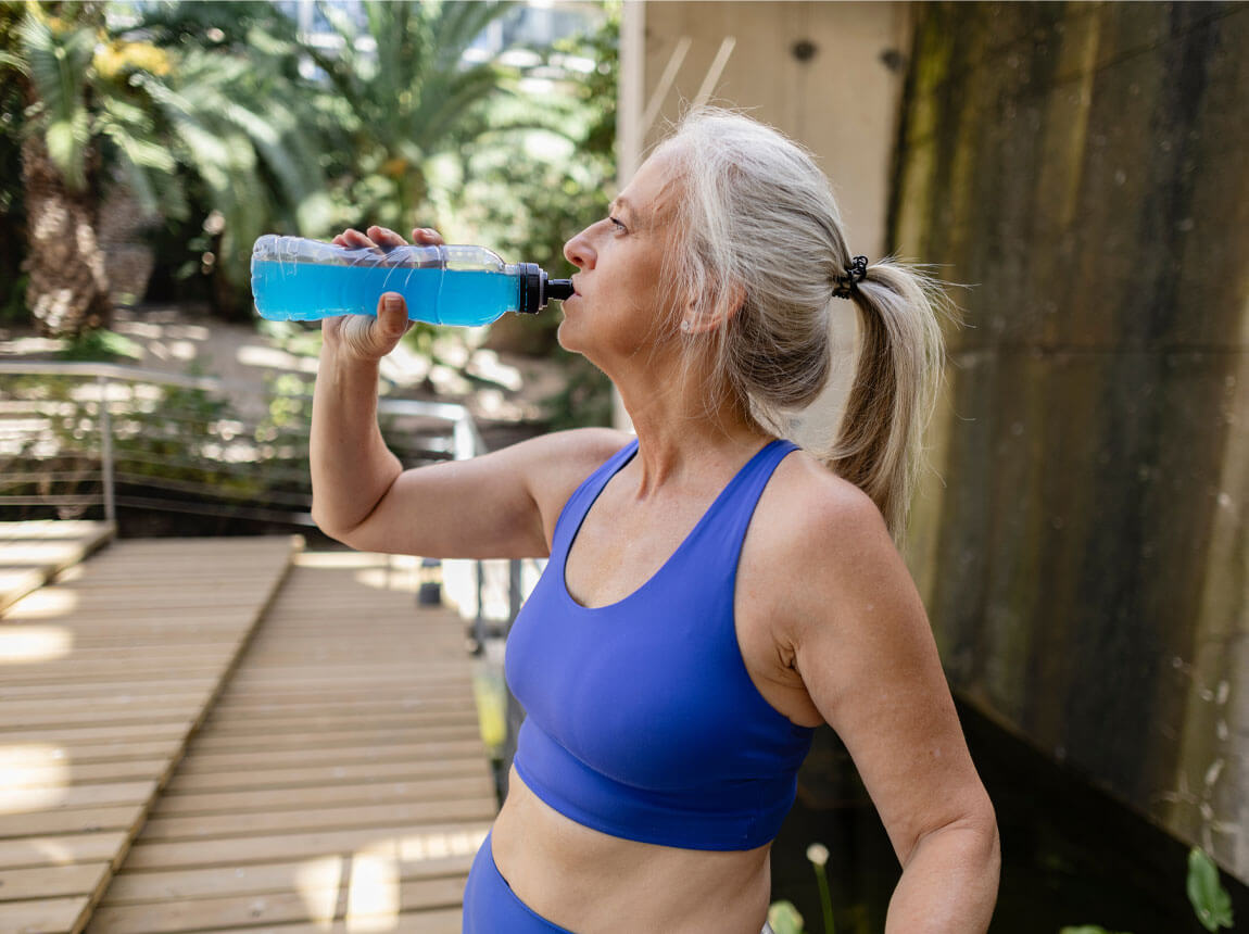 Активна літня жінка - ізотонічний напій