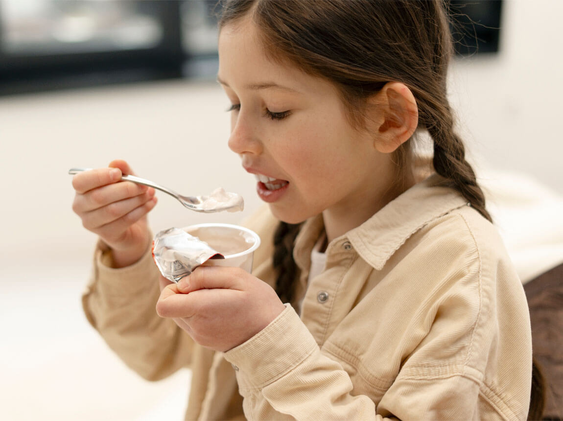 дівчинка з йогуртом - пробіотики для дітей